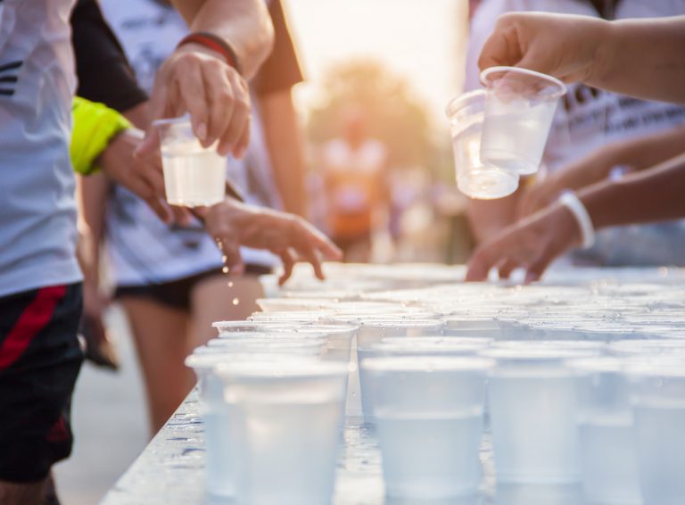 People running in city marathon on a street with sunrise