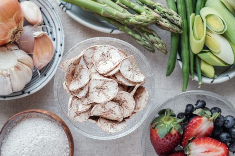 🥗 BIOKEMIJSKA ANALIZA TANJURA: "TVORNICA BUTIRATA" Svaki element na ovoj slici ima svoju ulogu u Vašem Butiratnom Protokolu: Zelene banane (čips od banane): Ovo je vizualni prikaz otpornog škroba (Resistant Starch Type 2). Kao što smo rekli, to je primarno gorivo za Faecalibacterium prausnitzii. Bez ovoga, vaši androgeni receptori ostaju "gluhi". Češnjak i luk (lijevo): Klasični prebiotici bogati inulinom. Oni su inicijatori fermentacije koji pripremaju teren za proizvodnju butirata u debelom crijevu. Šparoge i zelene mahune (gore): Izvori neprobavljivih vlakana koja osiguravaju sporu i stabilnu fermentaciju, sprječavajući nagle skokove inzulina i čuvajući osjetljivost na T3. Bobičasto voće (dolje desno): Polifenoli iz borovnica i jagoda djeluju sinergijski s butiratom u zaštiti endotela. Dok butirat popravlja "žbuku" na žilama, antioksidansi gase upalne požare.