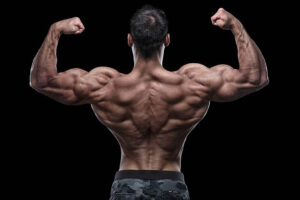 Body builder flexing biceps in front of black background